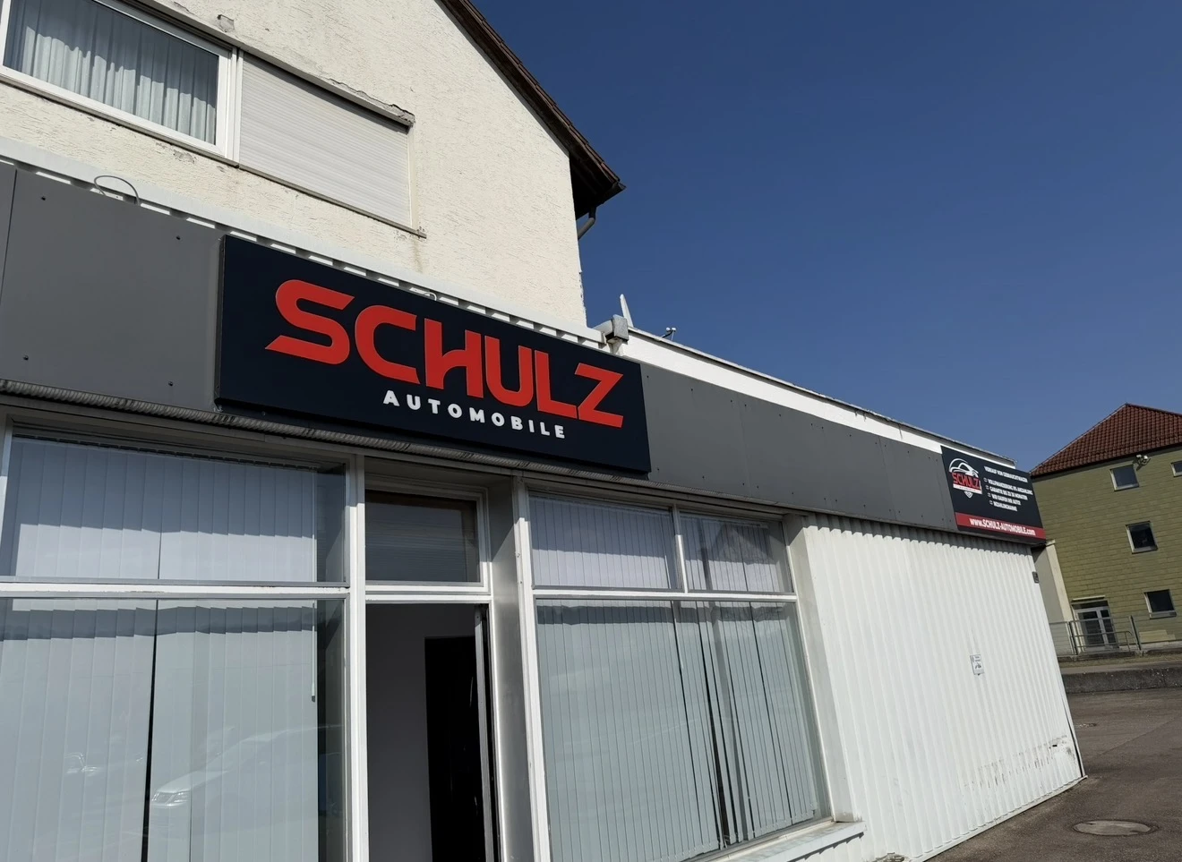 Schulz Automobile: Leuchtkasten mit leuchtenden Konturen an einem Automobilhandel